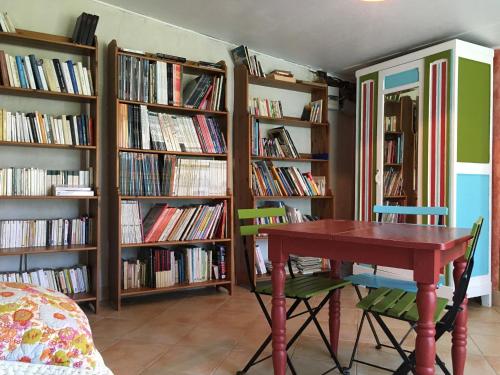 a room with a table and shelves of books at La Clef du Four in Plesder