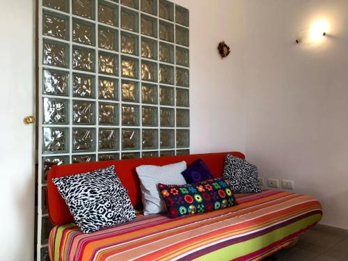 un sofá rojo con almohadas coloridas en una habitación en Belvedere Piano di Sorrento, en Piano di Sorrento