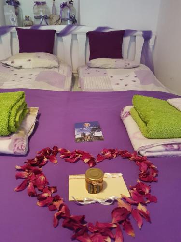 Una cama con un corazón hecho de flores. en Kis Sziget Vendégház, en Nagybörzsöny