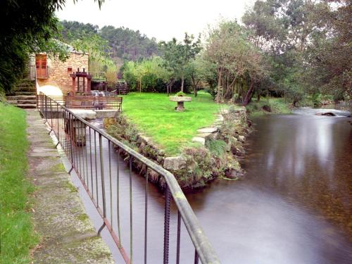 a bridge over a river next to a park at Finca Galea in Carballido
