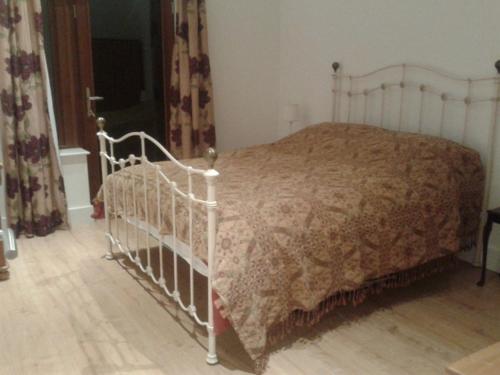 een slaapkamer met een wit bed en een dekbed bij Hilltop Lodge in Cultra