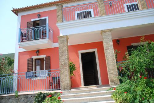 a pink house with stairs and a balcony at Anatoli Labreon in Agia Marina