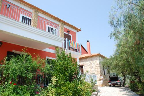 a red and white house with a fence at Anatoli Labreon in Agia Marina