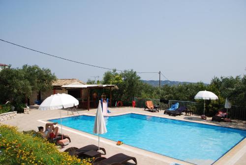 ein großer Pool mit Stühlen und Sonnenschirmen daneben in der Unterkunft Anatoli Labreon in Agia Marina