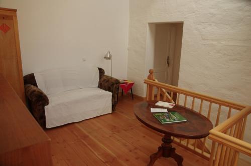 a living room with a chair and a table at Stützpunkt Trebitz - Gästezimmer am Europaradweg R1 in Brück