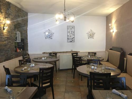 una habitación con mesas y sillas en un restaurante en Hotel Le Centre, en Brides-les-Bains