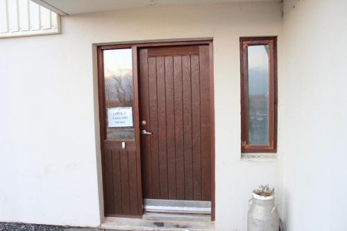 a brown door on the side of a house at Skammidalur Guesthouse in Vík