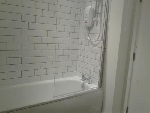 een badkamer met een bad en een telefoon aan de muur bij Hilltop Lodge in Cultra
