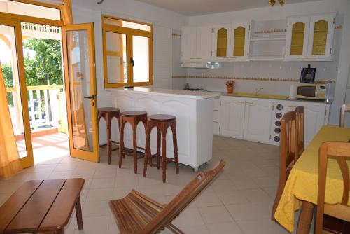 a kitchen with white cabinets and a table and chairs at Maison Duplex "Josué" vue sur Marina in Grand-Bourg