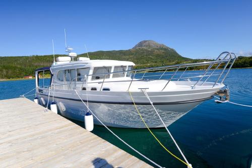a boat is docked at a dock in the water at Senja Fjordhotell and Apartments in Stonglandseidet