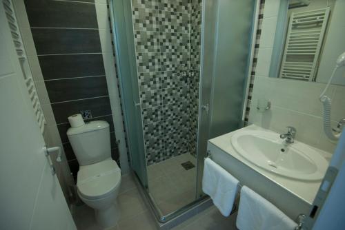 e bagno con servizi igienici, lavandino e doccia. di Hotel Village a Ohrid