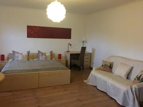 a bedroom with a bed and a couch and a table at Pension am Radweg & Ristorante Juani in Wriezen