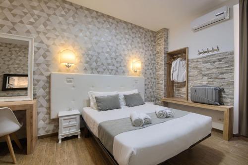 una camera da letto con un grande letto bianco in una stanza di Domus Pietro Inn a Roma