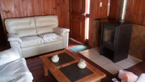sala de estar con sofá blanco y fogones en Cabañas Centro de Pucon, en Pucón