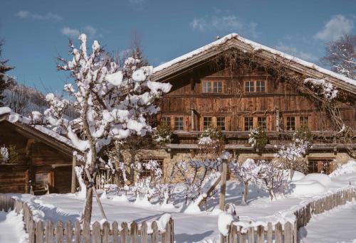 a wooden house in the snow with a fence at Chalet des Fermes de Marie, avec services, Collection Chalets des Fermes in Megève