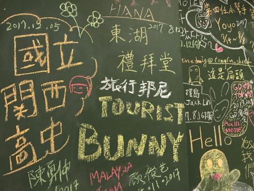 a chalkboard with writing and drawings on it at Tourist Bunny Hostel in Tamsui