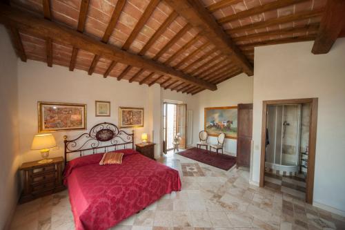 una camera con un letto con copriletto rosso di Agriturismo Podernuovo ad Asciano