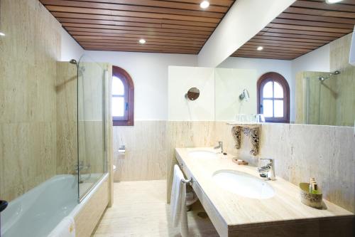a bathroom with a tub and a sink and a shower at Bodegas Hacienda Albae in Argamasilla de Alba