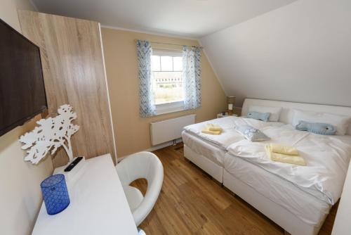 a bedroom with a white bed and a window at Premiumhaus Bodden und Mehr-Brise in Born