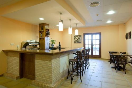 a bar in a restaurant with bar stools at Bodegas Hacienda Albae in Argamasilla de Alba