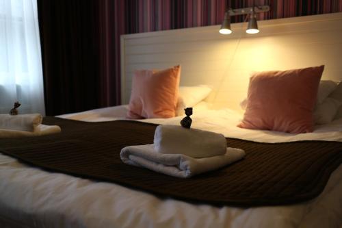 a bed with two towels on top of it at Hotell Marieberg in Kristinehamn