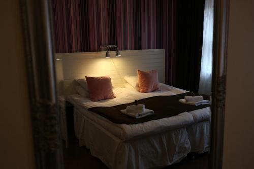 a hotel room with a bed with two cups on it at Hotell Marieberg in Kristinehamn