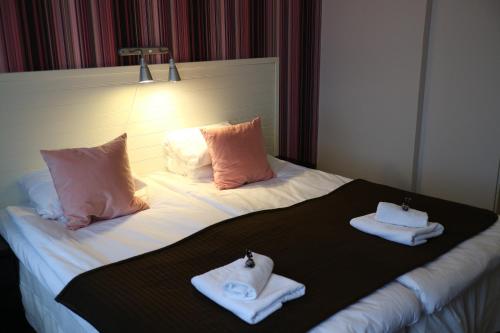 a hotel room with two folded towels on a bed at Hotell Marieberg in Kristinehamn