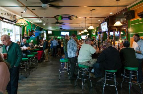 un grupo de personas sentadas en mesas en un bar en Irish American INN, en Newport
