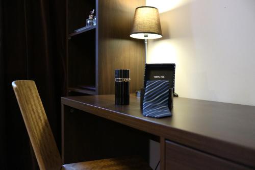 a desk in a hotel room with a lamp on it at Hotell Marieberg in Kristinehamn