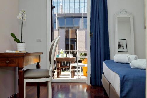 a bedroom with a bed and a desk and a window at Midnight in Rome Guest House in Rome