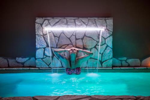 a woman is in the water in a pool at Hotel 87 eighty-seven - Maison d'Art Collection in Rome