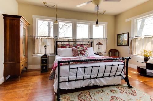 a bedroom with a bed in a room with windows at Travis Street in Fredericksburg