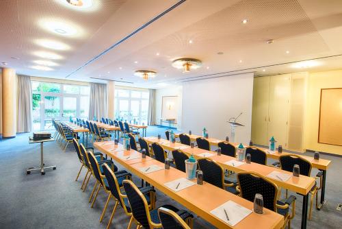 a conference room with tables and chairs and a screen at ACHAT Hotel Bad Dürkheim in Bad Dürkheim