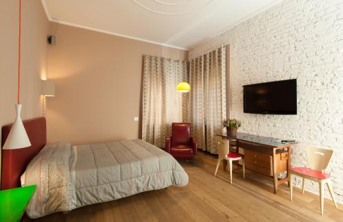 una camera d'albergo con letto, scrivania e TV di B&B Via Diaz a Bergamo