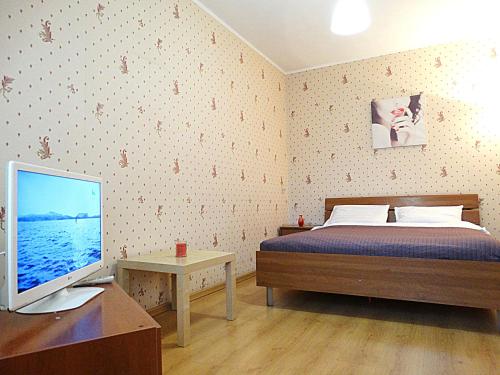 トゥーラにあるInndays on Kirova 151аのベッドルーム1室(ベッド1台、デスク、コンピュータモニター付)
