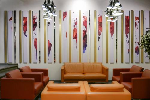 a waiting room with couches and flags on the wall at Atlas Hotel Brussels in Brussels
