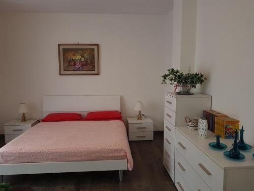 1 dormitorio con 1 cama con almohadas rojas y vestidor en In centro a Saint Vincent, en Saint Vincent