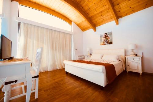 a bedroom with a bed and a desk and a television at Estrella Villas in Lartos