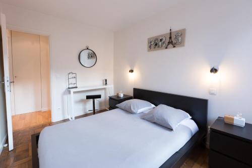 una camera da letto con un grande letto bianco con due cuscini di Apart By Jo - Proc 2F a Saint-Germain-en-Laye