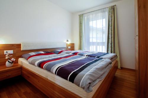 Haus Bergsonne في فلاخاو: سرير كبير في غرفة نوم مع نافذة