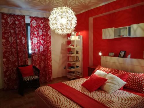 a red bedroom with a bed and a chandelier at villa peppino in Montallegro
