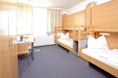 a room with two bunk beds and a desk at Jugendgästehaus Linz in Linz