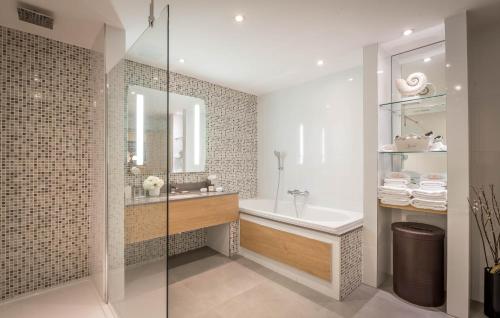 a bathroom with a tub and a sink and a shower at Clayton Hotel Burlington Road in Dublin