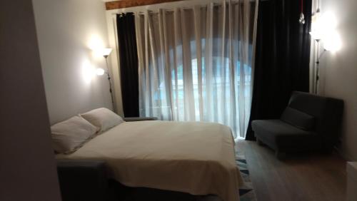 une chambre avec un lit, une chaise et une fenêtre dans l'établissement Sam Le Lezard Sarl, à Nice