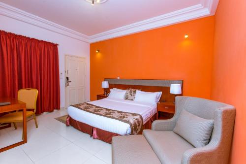 a hotel room with a bed and a desk and chairs at Le Feto 3 in Dakar