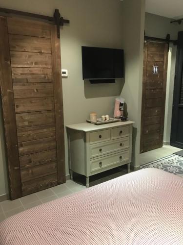 - une chambre avec une commode et une télévision murale dans l'établissement Céline et Olivier, à Pornic