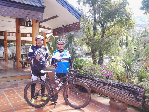 zwei Leute stehen neben einem Fahrrad in der Unterkunft Green Hill Resort Phurue in Phu Rua