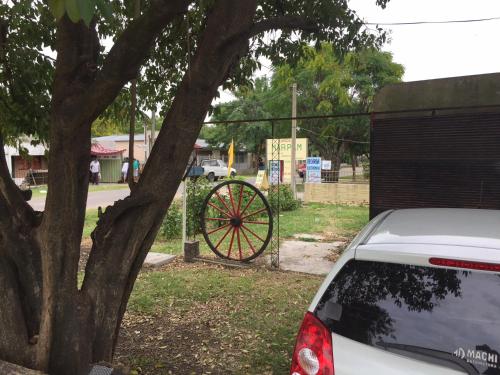 a car parked in front of a wheel next to a tree at las cuatro eme in Paysandú