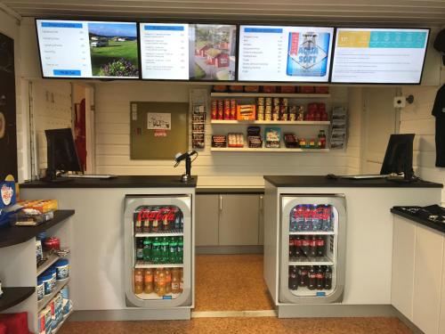 a store with two refrigerators and a counter with drinks at Haraldshaugen Camping in Haugesund