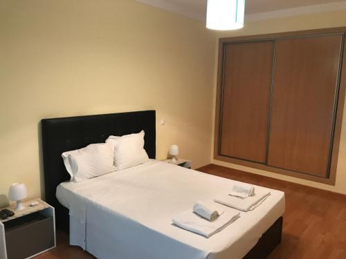 a bedroom with a large white bed with two towels on it at Apartamento T3 AL-GHARB in Armação de Pêra